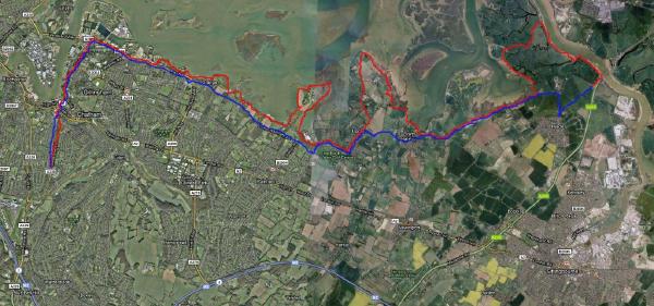 An aerial satellite map view showing a cycling route marked with colored lines blue, red, and purple sections that traces a path through the Medway estuary area near Chatham, passing through various locations including Upchurch, Lower Halstow, and extending toward the Isle of Sheppey, with the route clearly marked against the green landscape, waterways, and urban areas.